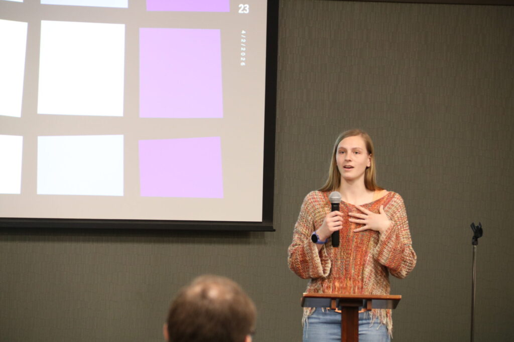 An Information Studies student speaking in front of a crowd